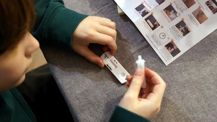 Un enfant fait un autotest de dépistage du Covid-19, le 7 janvier 2022, à Paris.&nbsp; (JEAN-BAPTISTE QUENTIN / MAXPPP)