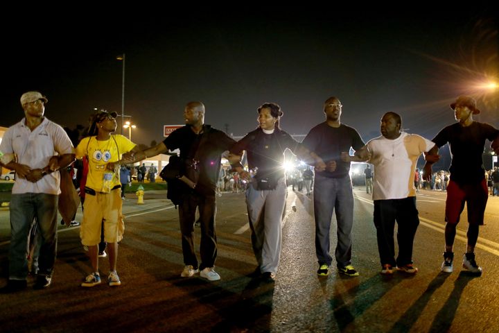 Des manifestants marchent &agrave; Ferguson (Etats-Unis), le 18 ao&ucirc;t 2014, pour protester contre la mort de Michael Brown, abattu par un policier. (JOE RAEDLE / GETTY IMAGES NORTH AMERICA / AFP)