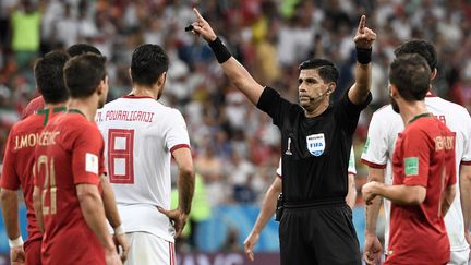 L'arbitre paraguayen&nbsp;Enrique Caceres demande l'assistance vidéo lors du match de Coupe du monde entre l'Iran et le Portugal, le 25 juin 2018 à&nbsp;Saransk&nbsp;(Russie). (FILIPPO MONTEFORTE / AFP)