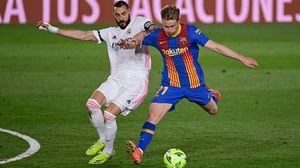 Karim Benzema en duel avec Frenkie De Jong le 10 avril 2021 à Madrid. (JAVIER SORIANO / AFP)