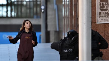 Une personne retenue en otage dans un caf&eacute; de Sydney (Australie) parvient &agrave; s'enfuir, lundi 15 d&eacute;cembre 2014.&nbsp; (SAEED KHAN / AFP)