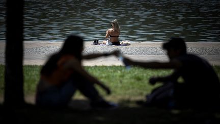 Une femme profite du soleil sur le bord de la Garonne à Toulouse, dans le sud-ouest de la France, le 17 mai 2022. (LIONEL BONAVENTURE / AFP)