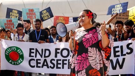 Une militante de l'association Fridays for Future appelle à la sortie des énergies fossiles à l'entrée de la "blue zone" de la COP28, à Dubaï, le 8 décembre 2023. (DOMINIKA ZARZYCKA / NURPHOTO / AFP)