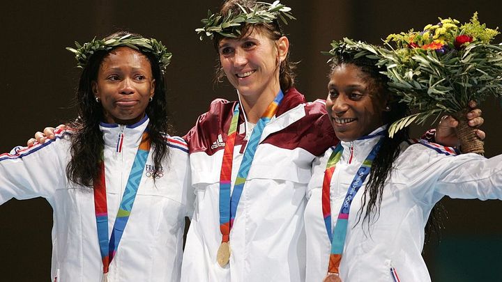 15 août 2004, Jeux olympiques d'Athènes, Laura Flessel monte sur la deuxième marche du podium et remporte une médaille d'argent. (Médaille d'or pour la hongroise Timea Nagy, et le bronze pour la française Maureen Nisima) (ANDREAS RENTZ / BONGARTS GETTY IMAGES)