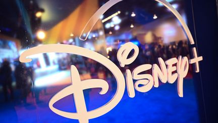 Les fans se reflètent dans le logo Disney + lors de la Walt Disney D23 Expo à Anaheim, en Californie le 9 septembre 2022 (PATRICK T. FALLON / AFP)