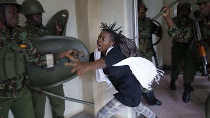 Une jeune femme tente d'&eacute;chapper &agrave; des policiers lors d'une manifestation &eacute;tudiante sur le campus de l'universit&eacute; de Nairobi (Kenya), le 20 mai 2014. (MAXPPP)