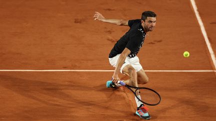 Gilles Simon en action sur le court Simonne-Mathieu de Roland-Garros pour son premier tour face à Pablo Carreno Busta, le 24 mai 2022. (THOMAS SAMSON / AFP)