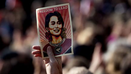 Un homme brandit un flyer de la leader de l'opposition birmane Ang San Suu Kyi venue recevoir son prix Nobel de la paix &agrave; Oslo (Norv&egrave;ge), le 16 juin 2012. (DANIEL SANNUM LAUTEN / AFP)