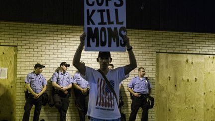 Un manifestant brandit une pancarte sur laquelle on peut lire "Les flics tuent les mamans", le 16 ao&ucirc;t 2014. ( LUCAS JACKSON / REUTERS )