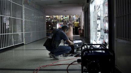 Un commerçant fait fonctionner un groupe électrogène pour palier une coupure d'électricité, à San Cristobal, au Venezuela, le 25 avril 2016.&nbsp; (CARLOS EDUARDO RAMIREZ / REUTEURS)