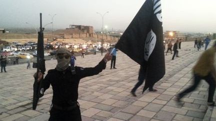 Combattant de Daech avec le drapeau de l'organisation djihadiste à Mossoul (Irak), le 24 juin 2014. (Reuters - Stringer)