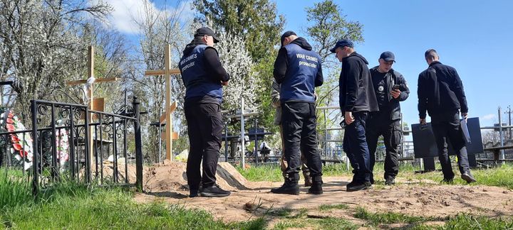 Le procureur adjoint de Boutcha, accompagné de gendarmes légistes français, recueille des preuves de crime de guerre dans un cimetière,&nbsp;près de Vorzel, au Nord-Ouest de Kiev (Ukraine). (ERIC AUDRA / RADIO FRANCE)