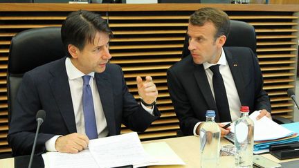 Le président de la République, Emmanuel Macron, et le chef du gouvernement italien, Giuseppe Conte,&nbsp;en discussion lors&nbsp;du sommet européen à Bruxelles, le 24 juin 2018.&nbsp; (DURSUN AYDEMIR / ANADOLU AGENCY / AFP)