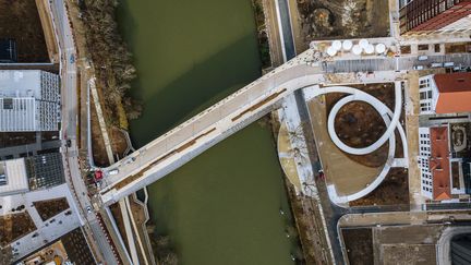 Au niveau de la place olympique, un pont a été construit pour relier la partie "continentale du village" à la partie "insulaire", autrement dit l'île Saint Denis. Des logements (environ 3 000 lits) et un restaurant secondaire ont également été construits sur l'île. Ces installations ne serviront que lors des Jeux olympiques, puisque les athlètes paralympiques sont moins nombreux que leurs homologues valides. (©SOLIDEO – Dronepress)