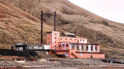 la localité fut fondée par des Suédois en 1910 pour exploiter une mine de charbon. Mais très vite, ils abandonnent leur projet et vendent la mine à l'Union soviétique en 1927. Elle fut rachetée par la compagnie minière russe de charbon Arktikougol en 1931. La centrale de cette photo créée en 1968 appartient toujours à la même compagnie. (CC BY-SA 3.0 (https://commons.wikimedia.org/wiki/File:Piramida_Svalbard_power_plant_IMG_7317.JPG))