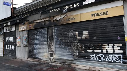 Le volet roulant brûlé d'un bureau de tabac après une nuit d'émeutes, à Talence (Gironde), le 1er juillet 2023. (ROMAIN PERROCHEAU / AFP)