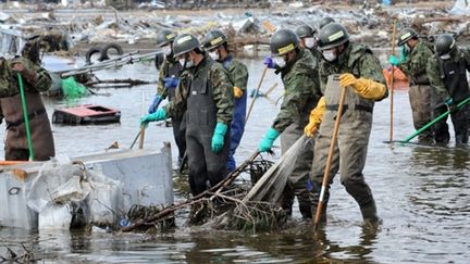 Les forces de défense japonaises recherchent des corps autour de Sendai, dans la préfecture de Miyagi. (AFP PHOTO / ROSLAN RAHMAN)