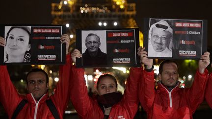 Des portraits de journalistes tués brandis par des membres de Reporters sans frontières, à Paris, le 1er novembre 2018. (GEOFFROY VAN DER HASSELT / AFP)