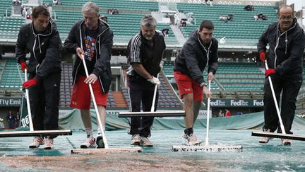 Et pendant que les équipes de Roland-Garros s'affairent pour préserver les courts... (THOMAS COEX / AFP)