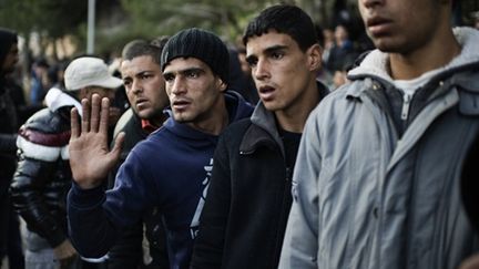 Clandestins tunisiens devant un centre d'accueil dans une rue de l'ile italienne de Lampedusa le 14 Février 2011 (AFP PHOTO / ROBERTO SALOMONE)