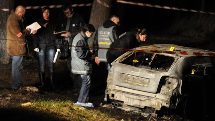 Les enqu&ecirc;teurs proc&egrave;dent aux premi&egrave;res investigations sur le v&eacute;hicule calcin&eacute; dans lequel trois corps ont &eacute;t&eacute; retrouv&eacute;s sur la commune des Pennes-Mirabeau (Bouches-du-Rh&ocirc;ne), le 26 d&eacute;cembre 2011. (GERARD JULIEN / AFP)