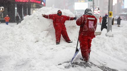 Entre deux coups de pelle, l'équipe chargée de déneiger Times Square, emmitouflée, très occupée depuis la nuit de samedi à vendredi, s'offre une pause. (SHANNON STAPLETON / REUTERS)