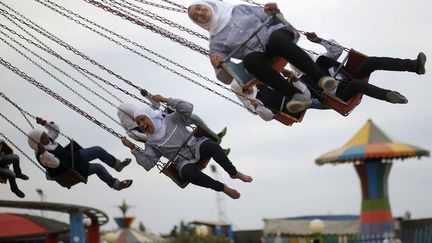 De jeunes Palestiniennes s'amusent dans un parc d'attraction dans la bande de Gaza (Palestine), le 11 avril 2013. (MOHAMMED SALEM / REUTERS)