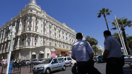 Des policiers montent la garde devant l'h&ocirc;tel Carlton de Cannes apr&egrave;s un vol de bijoux &agrave; main arm&eacute;, le 28 juillet 2013. (VALERY HACHE / AFP)