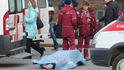 Docteurs des urgences debout devant le cadavre d'une personne tuée lors de l'explosion, à Minsk, le 11/4/2011 11/4/11 (AFP/Victor DRACHEV)