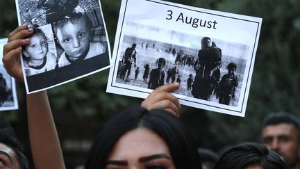 Des femmes yézidies irakiennes brandissent des pancartes avec des photos de victimes de l'invasion de leur région en 2014 par le groupe État islamique (EI), le 2 août 2019. Photo d'illustration. (Safin HAMID / AFP)