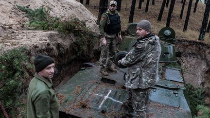 Des soldats ukrainiens entretiennent un véhicule militaire, le 28 octobre 2023, dans la région de Kharkiv (Ukraine). (DIEGO HERRERA CARCEDO / ANADOLU / AFP)