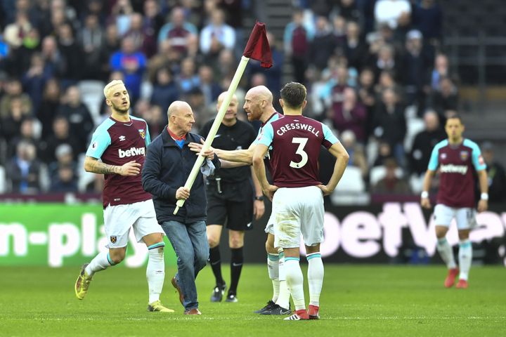 Paul Colborne entouré de joueurs de West Ham lors de l'envahissement du stade olympique de Londres, le 10 mars 2018 (BEN STANSALL / AFP)