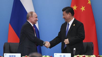 Le président chinois Xi Jinping (à droite), serre la main du président russe Vladimir Poutine a lors du sommet de l'Organisation de coopération de Shanghai (OCS) à Qingdao, dans la province chinoise du Shandong, le 10 juin 2018. (WANG ZHAO / AFP)