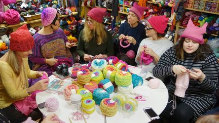 A New York, le 17 janvier 2017, des femmes tricotent des bonnets roses avec des oreilles de chats qu'elles coifferont pour la "Women's March", le 21 janvier à Washington. Une façon de rappeler les propos de Donald Trump se vantant d'attraper les femmes "par la chatte". (WILLIAM EDWARDS / AFP)