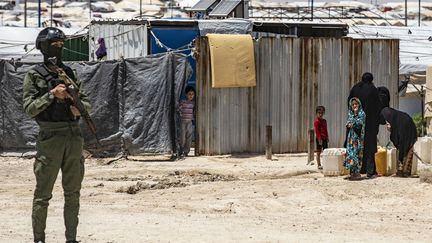 Un membre des forces kurdes monte la garde dans le camp de al Hol, en Syrie, qui abritent les familles de combattants de l’État islamique. (DELIL SOULEIMAN / AFP)