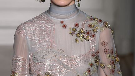 Pour sa première collection de haute couture chez Valentino  sans Maria Grazia Chiuri désormais chez Dior, Pierpaolo Piccioli a conçu des silhouettes hiératiques, auxquelles il a donné des noms de dieux et déesses de la mythologie grecque. Ces héroïnes défilent dans des robes, longues et plissées. Les tons écru, vert d'eau, rose poudré dominent la palette.
 (ALAIN JOCARD / AFP)