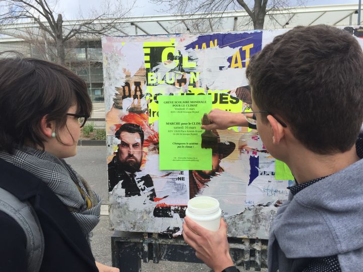 Deux élèves du lycée Camille Vernet collent des affiches pour annoncer la manifestation de vendredi 15 mars. (BORIS LOUMAGNE / RADIO FRANCE)