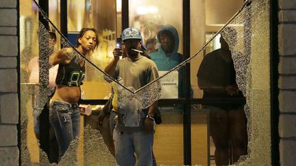 Des manifestant sont r&eacute;fugi&eacute;s dans un restaurant McDonald's alors que la police tire des gaz lacrymog&egrave;nes, le 17 ao&ucirc;t 2014. (CHARLIE RIEDEL / AP / SIPA)