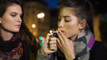 Deux jeunes femmes fumant du cannabis, un facteur de cancer.&nbsp; (SIGRID OLSSON / MAXPPP)