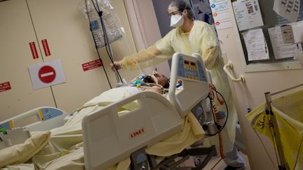 Une soignante prend en charge un patient atteint du Covid-19 dans le service de soins intensifs de Nantes (Loire-Atlantique), le 19 mai 2020.&nbsp; (LOIC VENANCE / AFP)