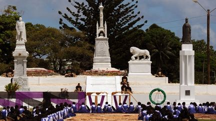 Des collégiennes formant une haie d'honneur baissent la tête par respect à l'arrivée du cercueil  au cimetière royal de Mala'ekula. (AFP PHOTO / Torsten BLACKWOOD)