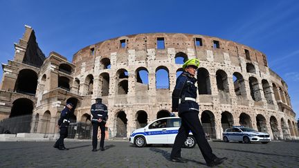 Des policiers municipaux patrouillent devant le Colisée, à Rome, le 10 mars 2020. (ALBERTO PIZZOLI / AFP)