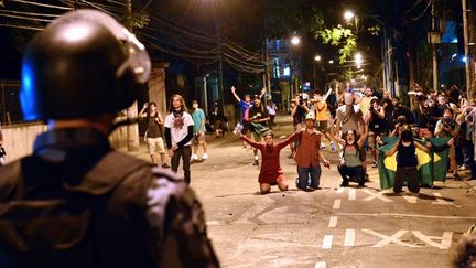 Des manifestants font face &agrave; la police, dimanche 30 juin 2013 dans les rues de Rio de Janeiro (Br&eacute;sil). (YASUYOSHI CHIBA / AFP)