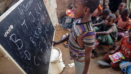 de jeunes enfants apprennent à lire et à compter dans une classe de fortune. Depuis mai 2017, des étudiants provenant de diverses universités assurent des cours gratuits à quelque 600 filles et garçons de moins de 16 ans. De nombreuses familles déplacées à Badbado viennent du camp de réfugiés tentaculaire de Dadaab au Kenya après l'annonce de sa fermeture. Le nombre de déplacés par le conflit et la sécheresse en Somalie devait atteindre trois millions fin 2017, selon les prévisions de l'UNHCR.  (Mohamed ABDIWAHAB / AFP )