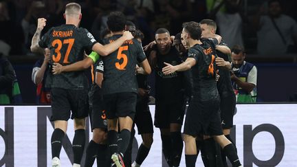 Les joueurs parisiens célèbrent l'ouverture du score de Kylian Mbappé contre Dortmund lors de la première journée de la phase de groupes de la Ligue des champions. (FRANCK FIFE / AFP)