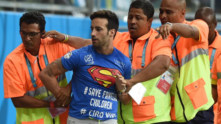 Mario Ferri est interpell&eacute; par la s&eacute;curit&eacute; apr&egrave;s avoir envahi le terrain lors de la rencontre entre la Belgique et les Etats-Unis, mardi 1er juillet &agrave; Salvador (Br&eacute;sil). (FRANCISCO LEONG / AFP)