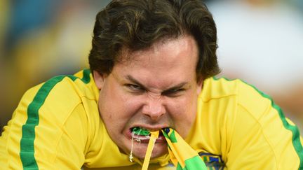 Un supporter br&eacute;silien r&eacute;agit &agrave; sa mani&egrave;re &agrave; l'&eacute;limination du Br&eacute;sil en demi-finale du Mondial (1-7 contre l'Allemagne), le 8 juillet 2014 &agrave; Belo Horizonte (Br&eacute;sil). (LAURENCE GRIFFITHS / GETTY IMAGES )