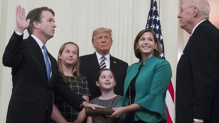 Brett Kavanaugh prête serment devant sa femme, ses filles, Donald Trump et&nbsp;Anthony Kennedy, ancien juge à la Cour suprême, le 8 octobre 2018 à la Maison blanche, à Washington. (JIM WATSON / AFP)