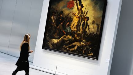 Une visiteuse passe devant "La Libert&eacute; guidant le peuple" d'Eug&egrave;ne Delacroix, au Louvre-Lens (Pas-de-calais), le 3 d&eacute;cembre 2012. (PHILIPPE HUGUEN / AFP)