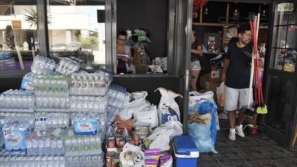 Des volontaires viennent en aide aux sinistrés de Mati, en Grèce, le 27 juillet 2018.&nbsp; (LOUISA GOULIAMAKI / AFP)